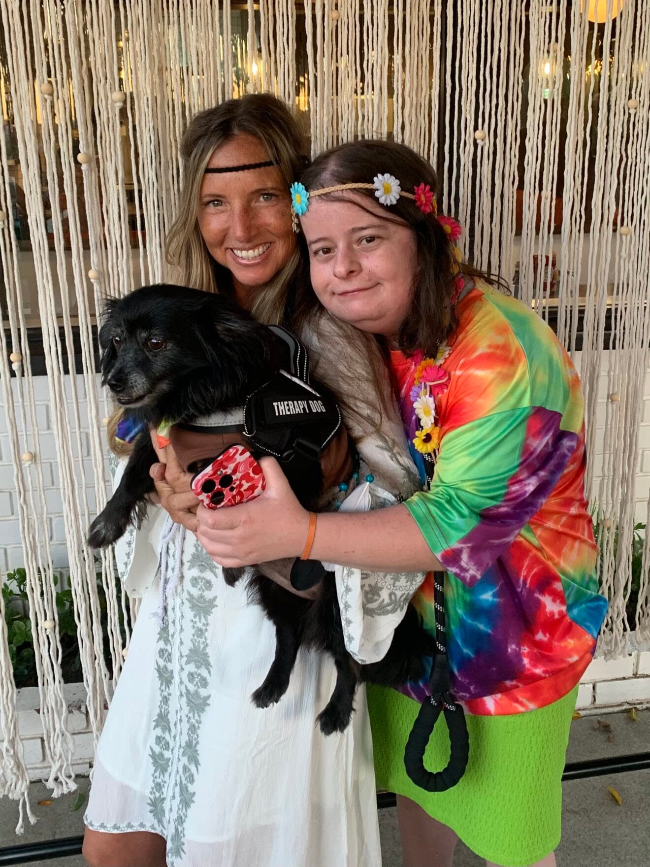 Jesi and Jordan smiling together with their therapy dog, showing the joy of life-sharing